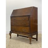 An early 20th century oak bureau, the fall front opening to skivered writing surface and fitted