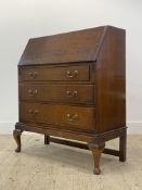 An early 20th century oak bureau, the fall front opening to skivered writing surface and fitted