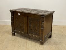 A 1930's oak coffer of 18th century design, floral carved hinged lid opening to a plain interior,