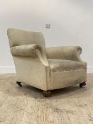 An early 20th century walnut framed upholstered armchair, with a raked back and deep seat, above