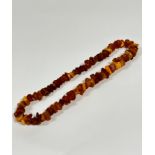 A dark honey and pale honey coloured natural nugget amber necklace. 30cm