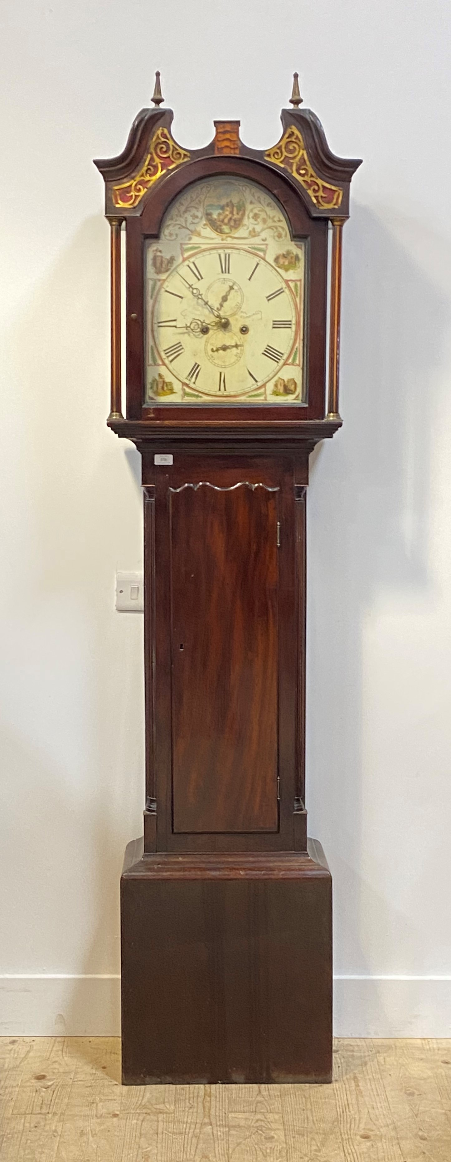 A mahogany longcase clock, first half of the 19th century, the hood with brass finials, swan neck