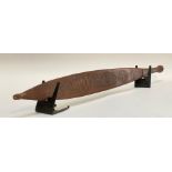 An Australian Aborigine Wommera (spear thrower), of slender form, the flat front carved with