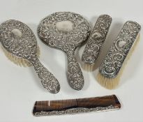 A modern Birmingham silver four piece chased dressing table brush set including hand mirror and