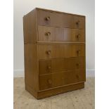 A mid century oak veneered chest by Meredew, fitted with five long drawers H107cm, W77cm, D47cm
