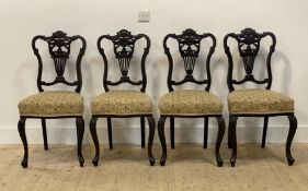 A set of four Late Victorian stained walnut drawing room chairs, scroll carved crest rail over