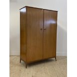 A mid century teak double wardrobe, the interior fitted for hanging, H178cm, W123cm D54cm