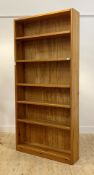 A large polished pine open bookcase fitted with five adjustable shelves, H211cm, W101cm, D26cm