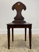 A mid 19th centrury mahogany hall chair, the scroll carved back rest over panelled seat, raised on