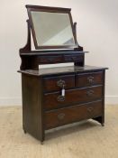 A late Victorian walnut dressing chest, the swing mirror over two trinket drawers, with two short
