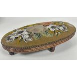 A Victorian treen oval foot rest with reeded moulded edge upholstered in beaded floral tapestry