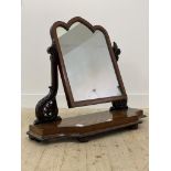 A Victorian Gothic mahogany swing mirror of large proportions, the arched frame with satinwood inlay