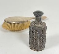 An Edwardian hammered silver hair brush (25cm) and an Eastern white metal cast open panel sided