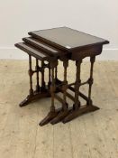A Reprodux Georgian style mahogany nest of three tables, square moulded tops inset with glass panels