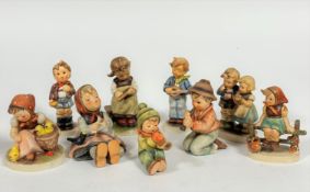 A collection of nine German Hummel pottery figures including two seated boys with instruments,