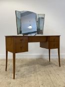 A mid century teak dressing table, the triptych mirror over one long and four short drawers,