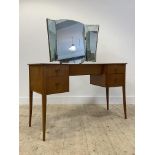 A mid century teak dressing table, the triptych mirror over one long and four short drawers,