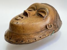 A southern African carved wooden wall mask, possibly Chokwe, Angola, with almond eyes, parted