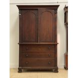 A 19th century continental mahogany linen press, the projecting cornice over two arch panelled doors