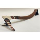 An Australian Aborigine hooked boomerang with painted decoration, with bands of black, white and red