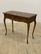 A cherry wood console table in the French taste, serpentine top over two frieze drawers, raised on
