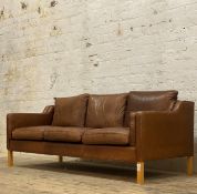 Habitat, a contemporary three seat sofa, upholstered in tan leather and raised on beech square