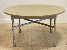 A late 20th century dining table, the circular top covered in faux leather over silver painted