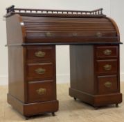 A late Victorian walnut roll top desk, with spindle gallery surmount of tambour front opening to
