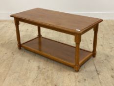 A Varnished cherry wood two tier coffee table raised on turned supports H47cm, 51cm x 100cm