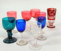 A collection of late 19th glass including three cranberry glasses on clear stems and another taller,
