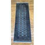 A blue ground Bokhara type rug, the field with two rows of guls within a multi line border 240cm x