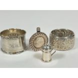 A Birmingham silver crenalated napkin ring, a Birmingham silver floral chased napkin ring, a