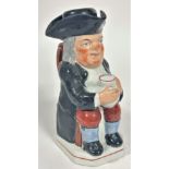 A 19thc Staffordshire Toby jug figure of a seated Gentleman with tricorn hat, complete with