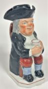 A 19thc Staffordshire Toby jug figure of a seated Gentleman with tricorn hat, complete with