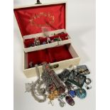 A white jewellery box containing a collection of costume jewellery including white metal chain