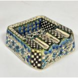 An Iznik pottery ashtray with well and three cigarette sections, decorated with all over flower