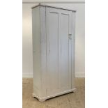 An early 20th century painted pine cupboard, single panelled door enclosing an interior fitted for