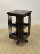 An Edwardian mahogany revolving bookcase, the top inlaid with satinwood bands, raised on a