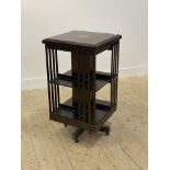 An Edwardian mahogany revolving bookcase, the top inlaid with satinwood bands, raised on a