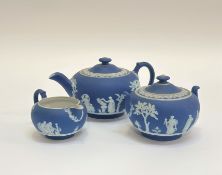 A three piece dark blue Wedgwood Jasperware part tea set comprising a milk jug ( h- 6cm) , a sugar