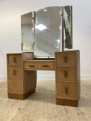 A 1930's dry oak and walnut dressing table, the top with three swing mirror over one long and