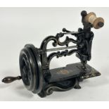 A Charles Raymonds late 19thc cast iron miniture table top manual sewing machine with black enamel