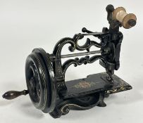 A Charles Raymonds late 19thc cast iron miniture table top manual sewing machine with black enamel
