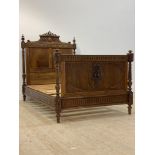 A continental panelled walnut single bed, early 20th century and later, the headboard carved with