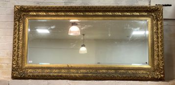 A large gilt composition framed wall hanging mirror of 18th century design, with floral moulded