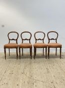 A set of four Victorian walnut dining chairs, with hooped back and scroll and floral carved rail,