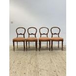 A set of four Victorian walnut dining chairs, with hooped back and scroll and floral carved rail,