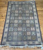A Persian style silk and cotton garden rug, the ivory field with panels depicting various motifs,