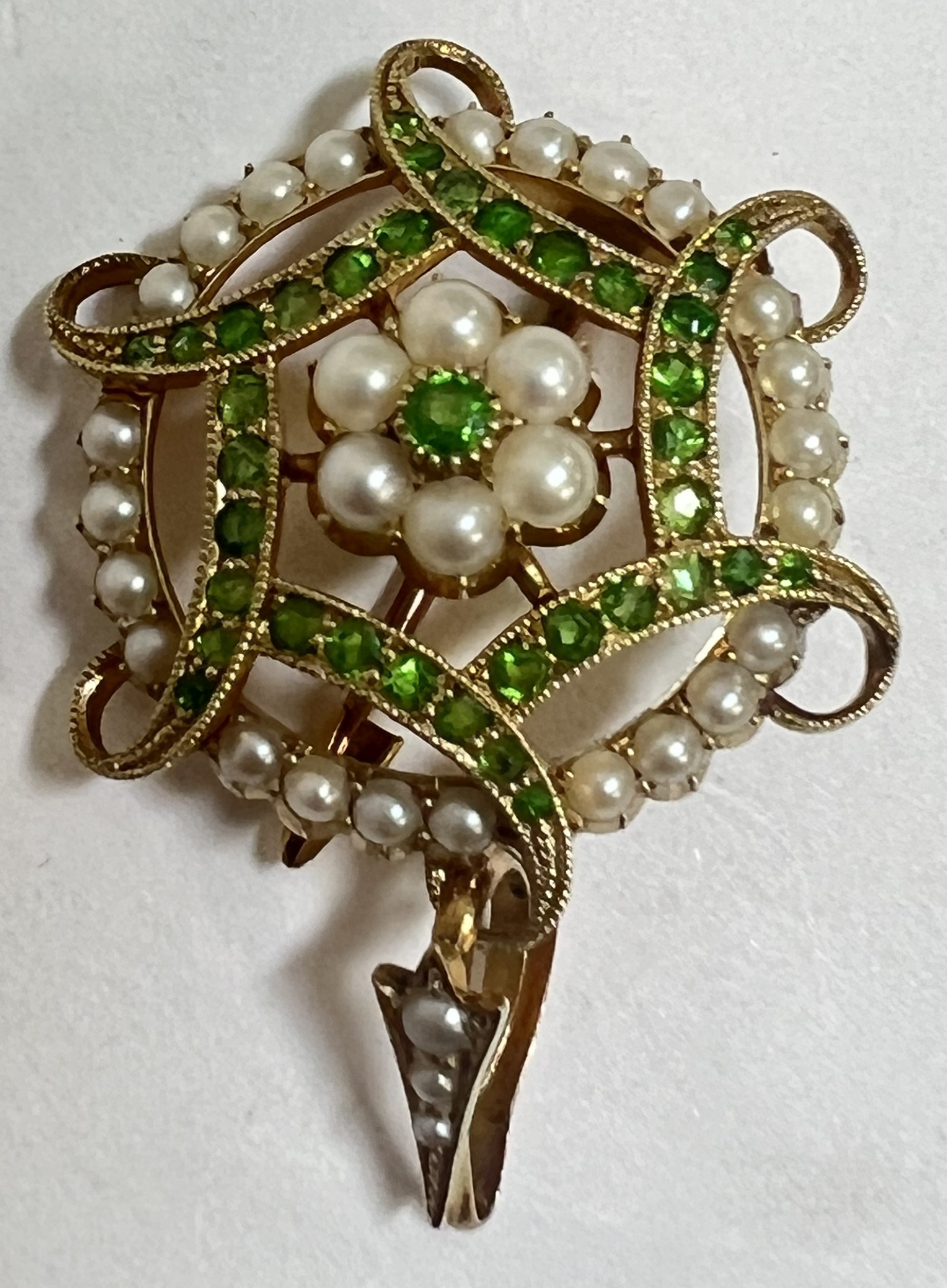 An Edwardian 15ct gold pendant brooch, the centre, set a green dematoid garnet within a surround of
