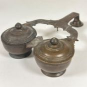 A late 19thc Indian bronze twin chamber condiment stand of triangular form with sliding domed covers
